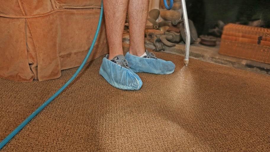 carpet cleaning technician spraying cleaning solution into carpet